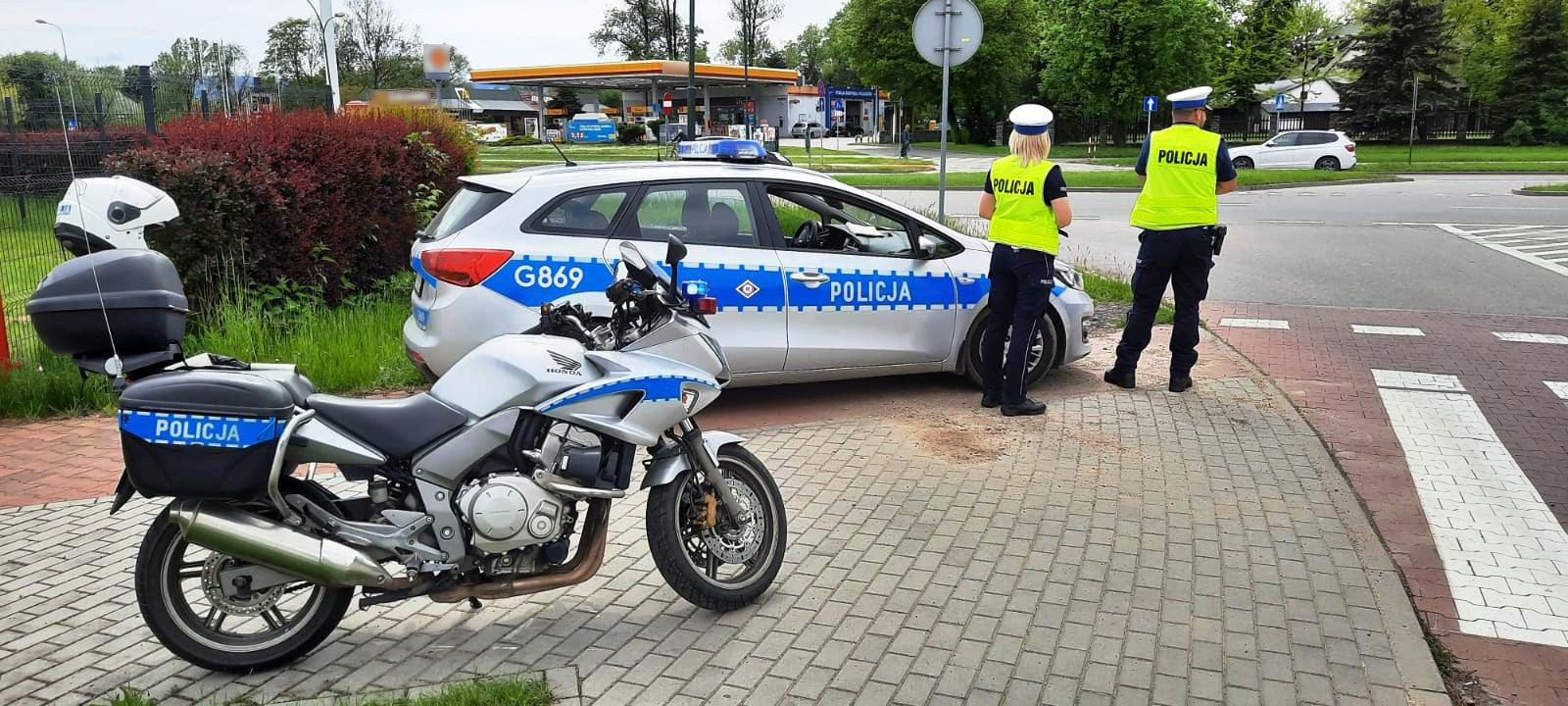 Służbowy motocykl i radiowóz, obok policjanci ruchu drogowego - fot. KMP Nowy Sącz