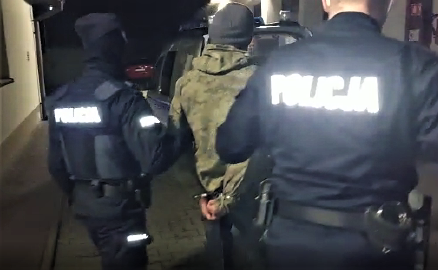Umundurowani policjanci prowadzą sprawcę do radiowozu - fot. KMP Nowy Sącz