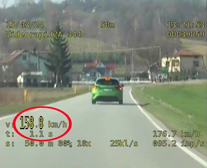 stopklatka z nagrania z wideorejestratora - widoczny zielony samochód i prędkość z jaką się porusza